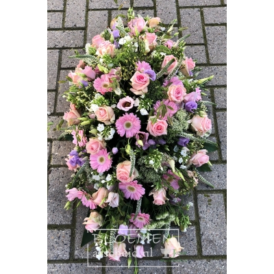 Ovaal rouwarrangement van zacht roze en witte bloemen met paars-blauwe accenten